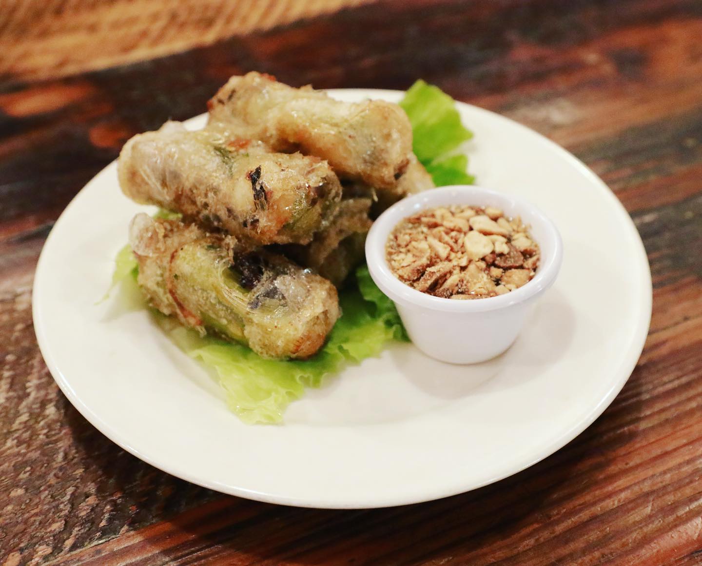 Traditional Vietnamese chả rấm fried spring rolls with ground pork filling and crushed peanut dipping sauce at La Ca Bar, Tacoma